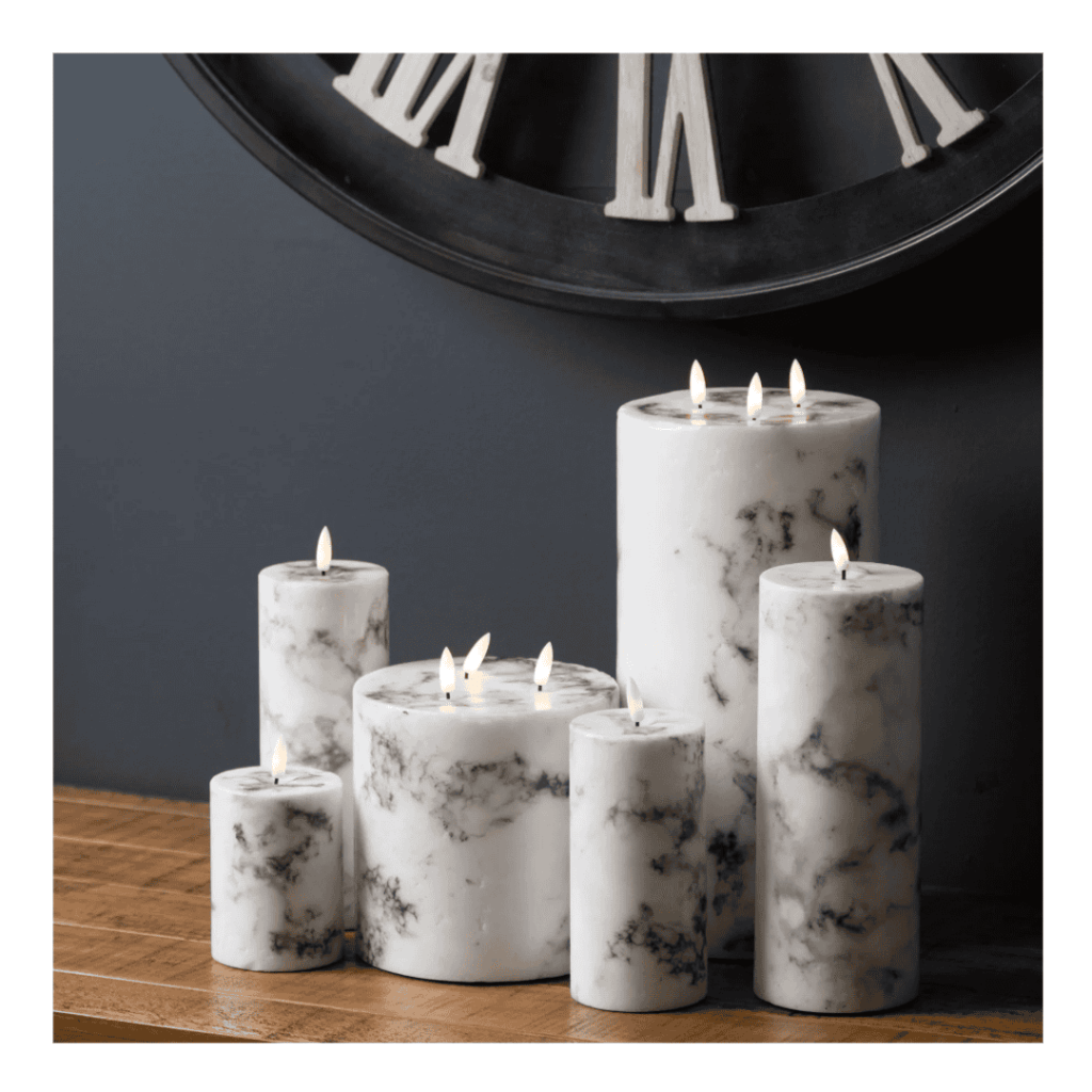 Elegant marble-patterned candles on a wooden table, perfect for modern home decor.
